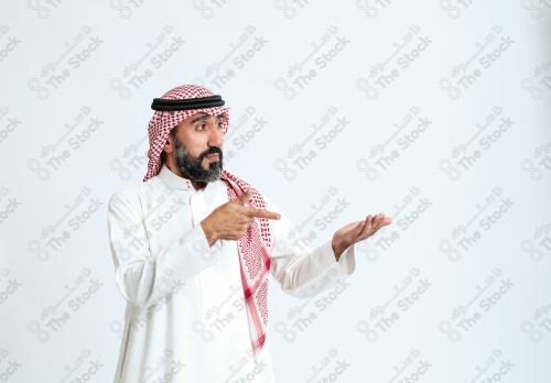 بورتريه رجل سعودي كبير بالسن يرتدي الزي الرسمي التقليدي على خلفية بيضاء يقوم بعمل اشارات بيديه وهو مبتسم ، حزين، غاضب، صور تذكارية ، توثيق لحظة سعيدة.