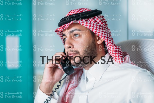 موظف سعودي يتحدث عبر الهاتف في مكتبه.