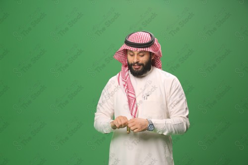 بورتريه رجل سعودي يرتدي الزي السعودي التقليدي يفتح غلاف الحلوى