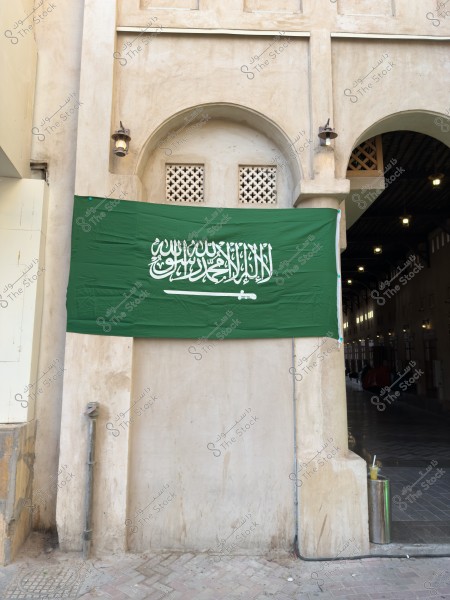 العلم السعودي معلق على مبنى طيني