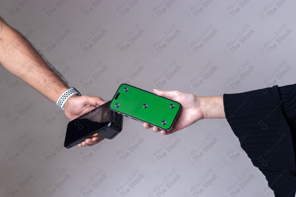 Portrait of a Saudi woman holding a card and making automatic payments on a white background