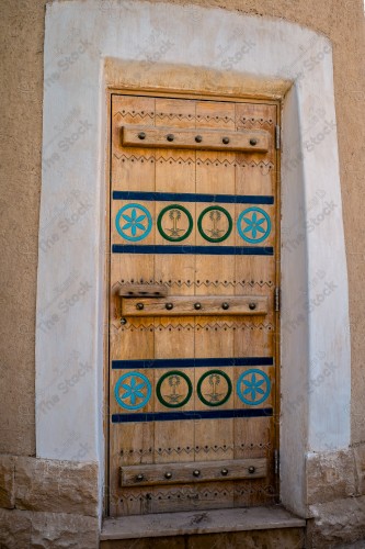 Wooden Antique door built into mud wall - Old traditional wooden door in Saudi Arabia