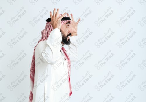 بورتريه رجل سعودي كبير بالسن يرتدي الزي الرسمي التقليدي على خلفية بيضاء يقوم بعمل اشارات بيديه وهو مبتسم ، حزين، غاضب، صور تذكارية ، توثيق لحظة سعيدة.