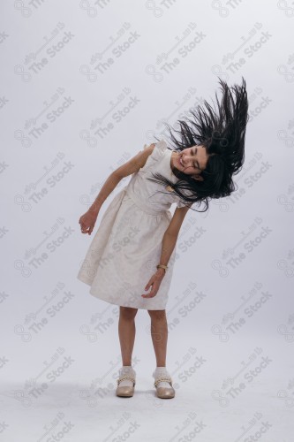 Portrait of a Saudi girl on a white background making gestures with her hands while smiling, souvenir photos, documenting a happy moment, Eid candy, Eid gifts, Eidiyat