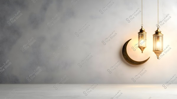 An image featuring two traditional golden lanterns lit and hanging on a light gray wall. Next to them is a decorative golden crescent moon hanging from the wall. The surface below the lanterns and crescent is a soft white, creating a calm and warm ambiance.