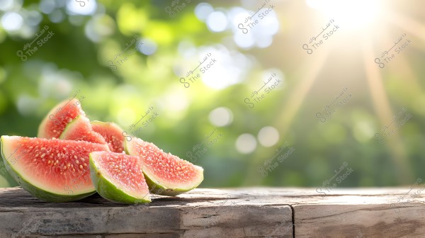 Slices of ripe red watermelon with green rinds placed on a wooden table. Bright sunlight is visible in the background along with blurred green foliage, creating a refreshing and natural atmosphere.