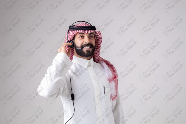 بورتريه رجل سعودي يلبس سماعة الرأس ويقوم بالتواصل عبر السماعة - خدمة العملاء ، مكالمة هاتفية