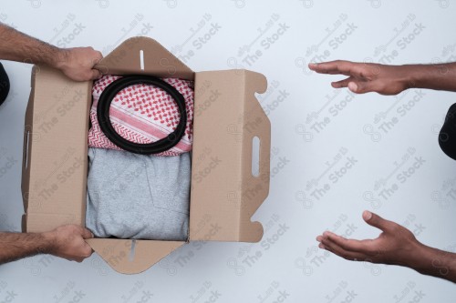 جمع تبرعات و تجهيزها للمحتاجين، صندوق ممتلئ بالملابس على خلفية بيضاء