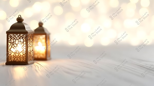 Two traditional Arabic lanterns lit on a wooden surface with intricate star-shaped patterns, set against a warmly lit bokeh background, creating a cozy and festive atmosphere.