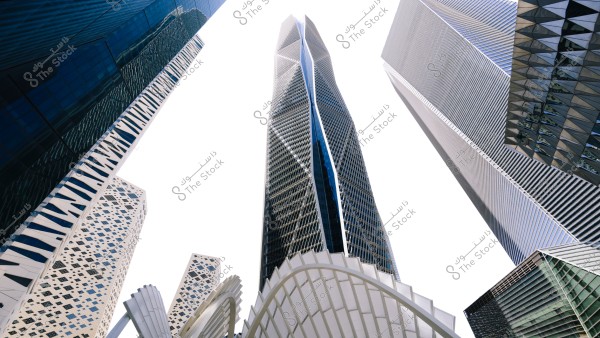 The image shows a collection of modern skyscrapers with sleek and uniform designs under a bright white sky. The buildings feature glass and metal facades that reflect light, and some have intricate geometric patterns and structures that highlight advanced architectural styles.
