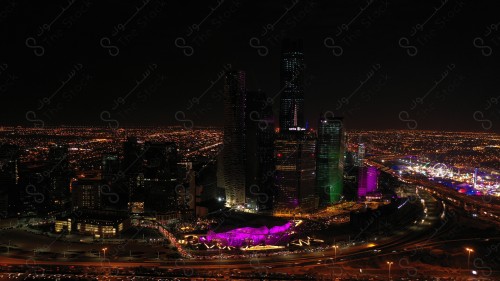 A shot showing the buildings and landmarks of the King Abdullah Financial District in the city of Riyadh, in front of it a group of residential houses with traffic.