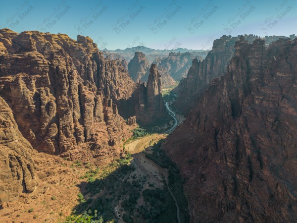 An aerial shot of Wadi Al-Disa in Tabuk, showing the mountains during the day, Saudi valleys, and nature in Saudi Arabia.