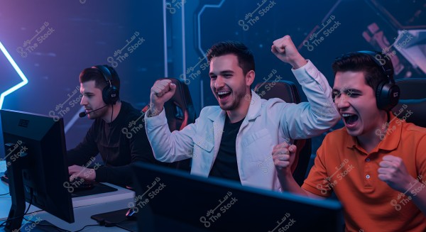 The image shows three people sitting in front of computer monitors in a neon-lit environment, suggesting they are in a competition or group gaming session. The person in the middle is wearing a white jacket and looks excited, while the person on the right is in an orange shirt and appears enthusiastic. The person on the left is wearing black clothing and is focused on the screen, wearing a gaming headset.