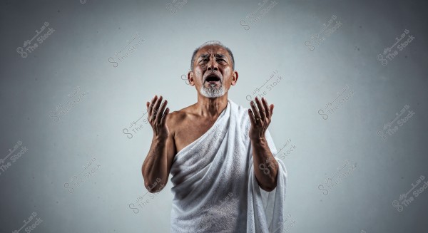 Image of a man wearing a white Ihram garment, appearing to be in a praying position. The background is neutral and simple, highlighting the person in the foreground.
