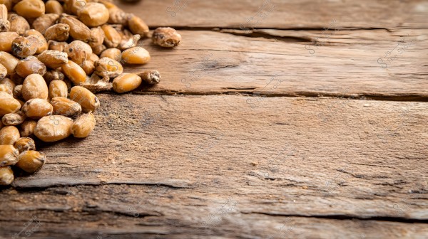 An image showing a collection of dried corn kernels scattered on an old, brown wooden surface. The corn appears dark and varies in shapes and sizes, occupying the left half of the image, while the right half remains mostly empty.
