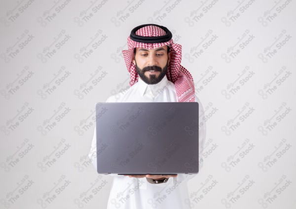 Portrait of a Saudi man holding a laptop and making different expressions, customer service, and communication.