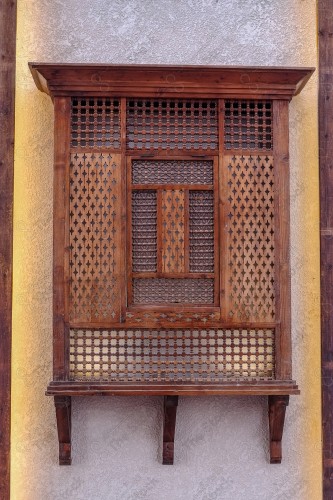 Detail of an old wooden window in a mud wall, decorative wooden window.