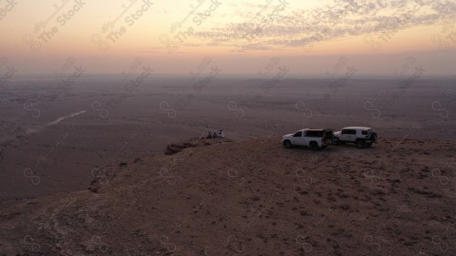 لقطة جوية لمجموعة سياح على جبل من جبال طويق المسمى بحافة العالم. سلسلة من الجبال الصخرية