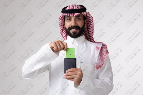 بورتريه رجل سعودي يحمل بطاقة خضراء على خلفية بيضاء