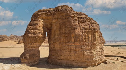 جبل الفيل يتوسط الصحراء في العلا وتظهر السماء شبه صافية نهارًا