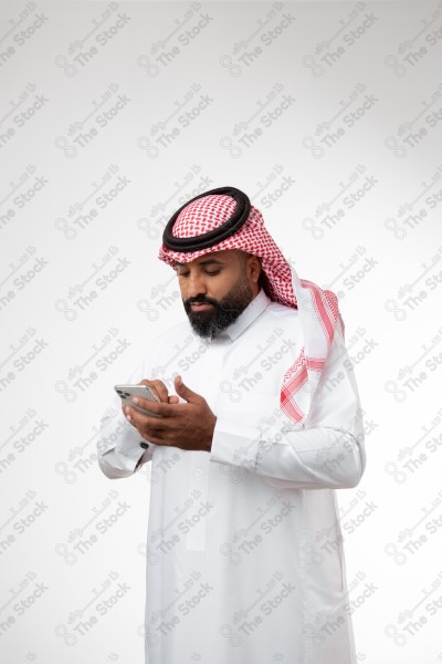 Portrait of a Saudi man holding a phone and making different expressions, white background