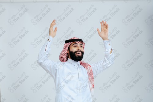 Portrait of a Saudi man in free uniform on a white background making gestures with his hands while smiling, souvenir photos, documenting a happy moment.