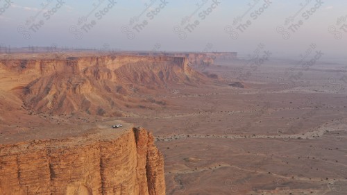 لقطة جوية لمجموعة سياح على جبل من جبال طويق المسمى بحافة العالم. سلسلة من الجبال الصخرية