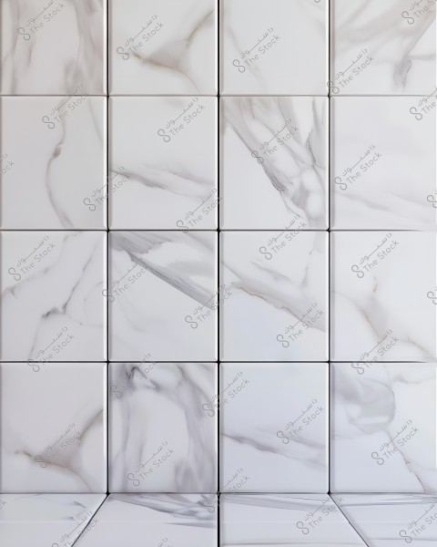 Image of ceramic tiles with a marble design. The tiles are white with gray veins and lines running across the surface, giving an elegant and attractive appearance. The tiles are arranged evenly in rows and columns, forming a repetitive pattern.
