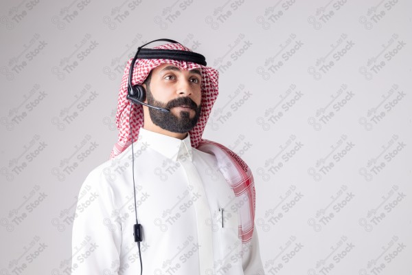 بورتريه رجل سعودي يلبس سماعة الرأس ويقوم بالتواصل عبر السماعة - خدمة العملاء ، مكالمة هاتفية