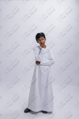 Portrait of a Saudi child on a white background making gestures with his hands while smiling, souvenir photos, ، documenting a happy moment, Eid candy, Eid gifts, Eidiyat, incense