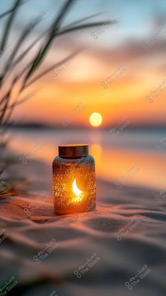 Image showing a sunset on a sandy beach, with a lit glass lantern featuring a crescent design in the foreground. The lights beautifully reflect on the sand with the sky\'s gradient colors ranging from blue to orange.