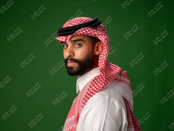 رجل يرتدي الثوب السعودي والغترة الحمراء على خلفية خضراء.