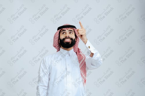 Portrait of a Saudi man in free uniform on a white background making gestures with his hands while smiling, souvenir photos, documenting a happy moment.