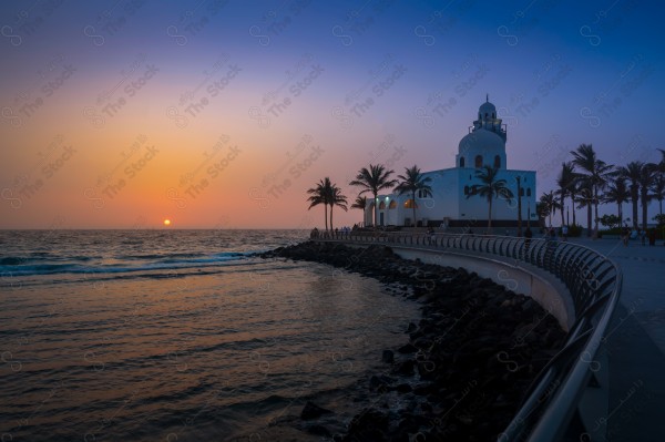 An aesthetic shot of Al Jazeera Mosque in Jeddah at sunset, showing a clear sky, rivers and seas, trees and palm trees, and nature in Saudi Arabia.