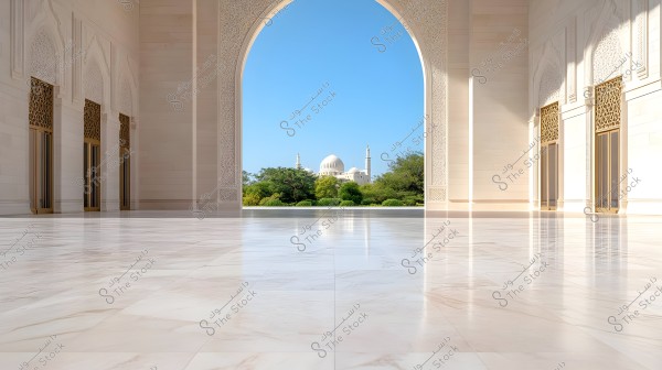 The image shows a wide outdoor courtyard with a polished marble floor leading to a decorative Islamic-style archway. The archway frames a view of a mosque with white domes and minarets surrounded by green trees under a clear blue sky.