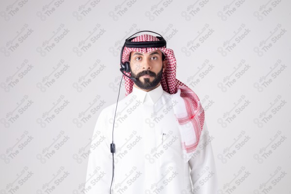 بورتريه رجل سعودي يلبس سماعة الرأس ويقوم بالتواصل عبر السماعة - خدمة العملاء ، مكالمة هاتفية