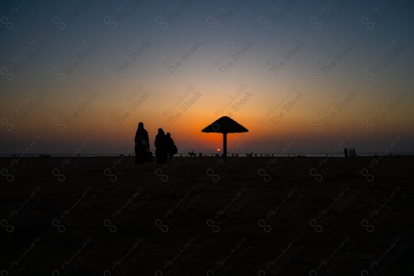 Silhouette of people walking on the beach in the evening at Al Seif Beach in Jeddah, Saudi Arabia