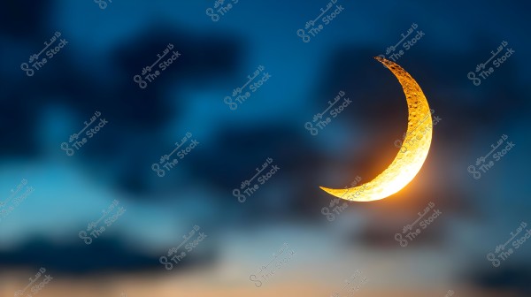 An image of a glowing crescent moon in the sky during sunset. The crescent moon is prominently illuminated in golden color, with dark clouds in the background adding a dramatic effect to the scene. The sky features gradients from blue to light orange.