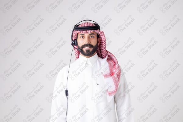 بورتريه رجل سعودي يلبس سماعة الرأس ويقوم بالتواصل عبر السماعة - خدمة العملاء ، مكالمة هاتفية