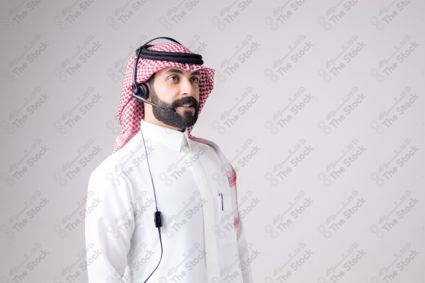 بورتريه رجل سعودي يلبس سماعة الرأس ويقوم بالتواصل عبر السماعة - خدمة العملاء ، مكالمة هاتفية