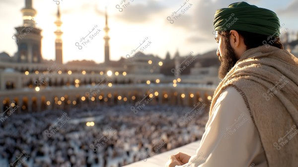 An image of a man looking toward the Grand Mosque in Mecca during sunset. The man is wearing a green turban and a light brown cloak, resembling traditional attire. In the background, the mosque\'s minarets and domes are visible, with lights illuminating the courtyard filled with worshippers.