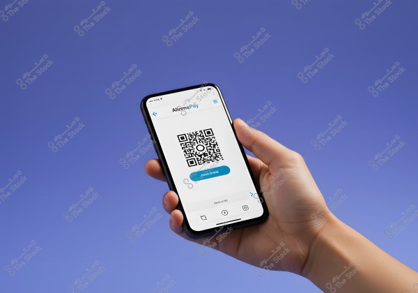 The image shows a hand holding a smartphone displaying an app called \"Alinma Pay\" with a QR code in the center of the screen. The background is blue.