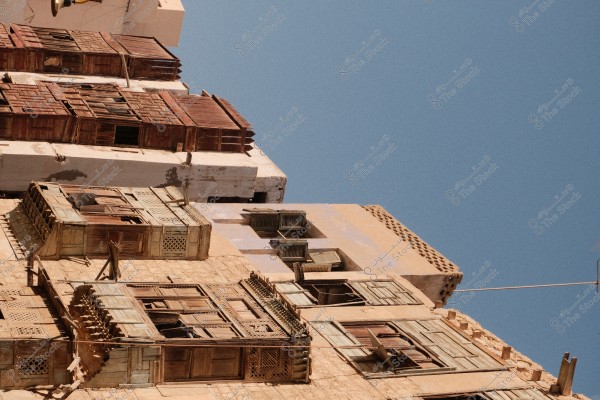 An old building with traditional wooden windows under a clear blue sky.