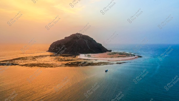 صورة جوية لجزيرة صغيرة وسط المحيط الهادئ, تظهر في وسطها تلة صخرية مظلمة محاطة بشريط رمال بيضاء تمتد حول الجزيرة. اللون البرتقالي للشمس الغاربة ينعكس على المياه المحيطة, مما يخلق تأثيراً جمالياً يعزز من جمال المشهد الطبيعي.