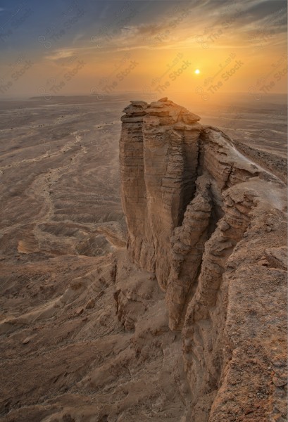 لقطة جوية لجبل من جبال طويق المسمى بحافة العالم في السعودية وتظهر السماء صافية. سلسلة من الجبال الصخرية، غروب الشمس