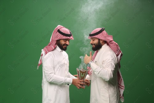 رجل سعودي يرتدي الزي السعودي التقليدي يبخر ضيفه في أحد المناسبات