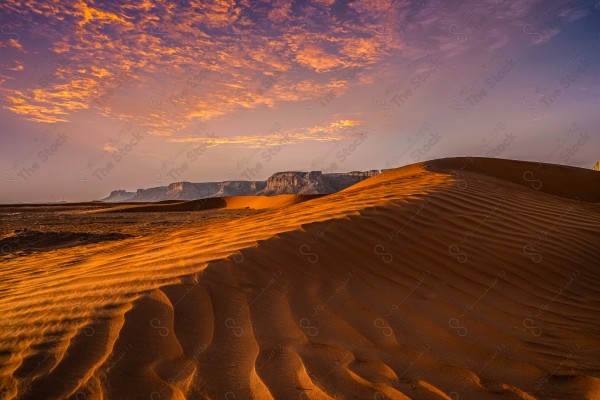 غروب الشمس فوق الرمال الحمراء في الرياض، المملكة العربية السعودية.