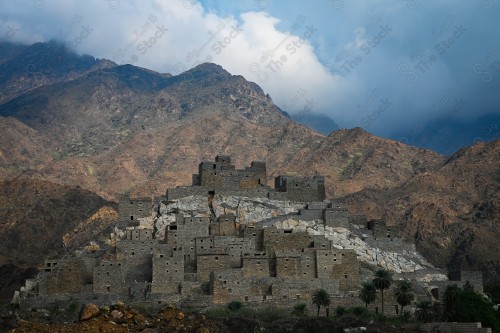 An overhead shot of a series of rocky mountains, in the middle of which is the ancient village of Dhi Ain in Al-Baha, archaeological tourist attractions.