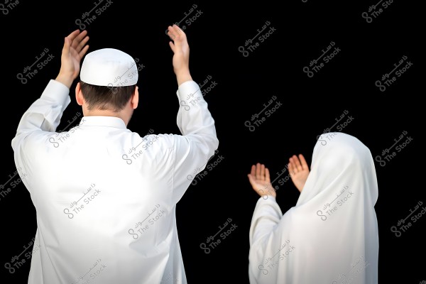 A man and a woman in white clothing raising their hands in prayer at Kaaba.