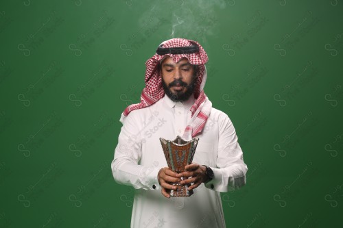 بورتريه رجل سعودي يرتدي الزي السعودي التقليدي يحمل المبخرة